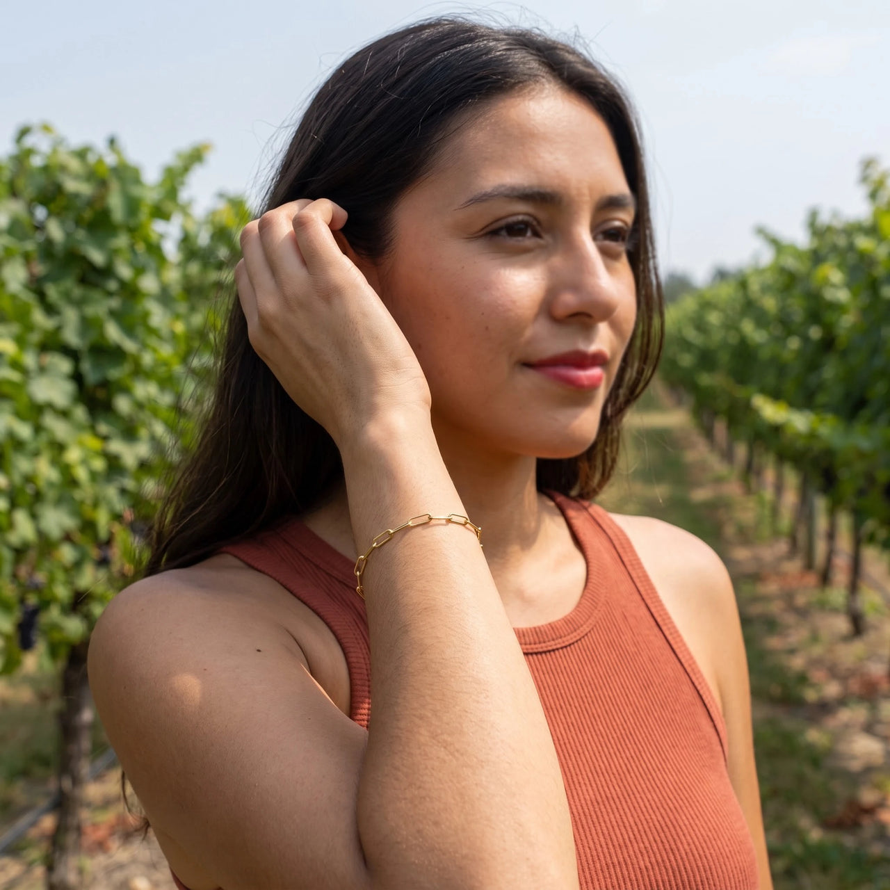 Woman gently touching her Original bracelet in gold | SKU: l-original