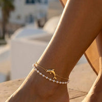 Thumbnail for Pearl Dolphin Anklet Set worn on the ankle on a Mediterranean terrace at golden hour, by Brother & Sisters.