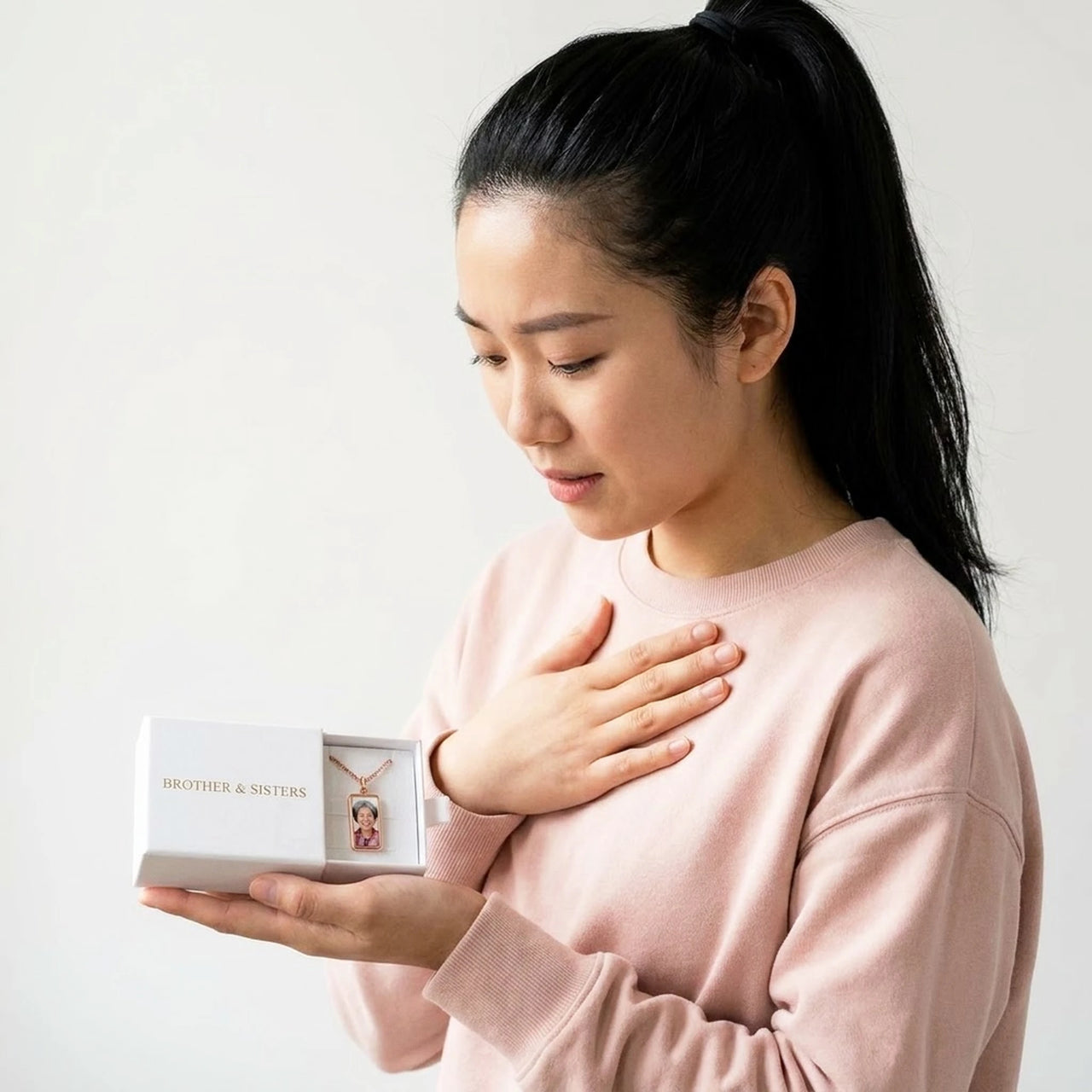 The rose gold bar photo necklace in the Brother & Sisters gift box, held in her palm | SKU: TPH-BARN-ROSEGOLD