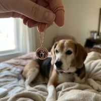 Thumbnail for Customer photo: the rose gold round necklace with her beagle's photo, her dog in the background | SKU: TPH-RNDN-ROSEGOLD